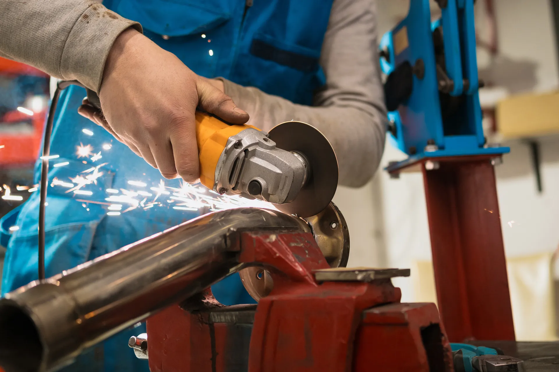 Technician cutting metal with sparks flying in the workshop