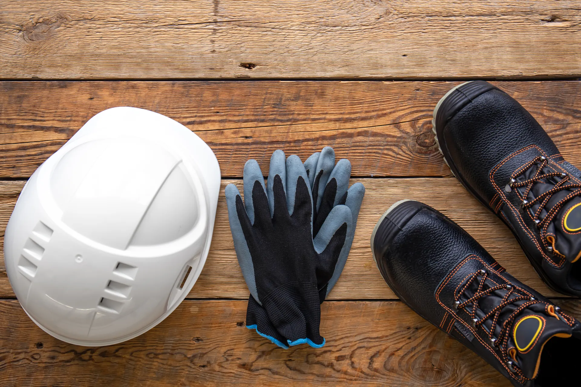 Safety helmet, boots, and protective gloves laid out for work