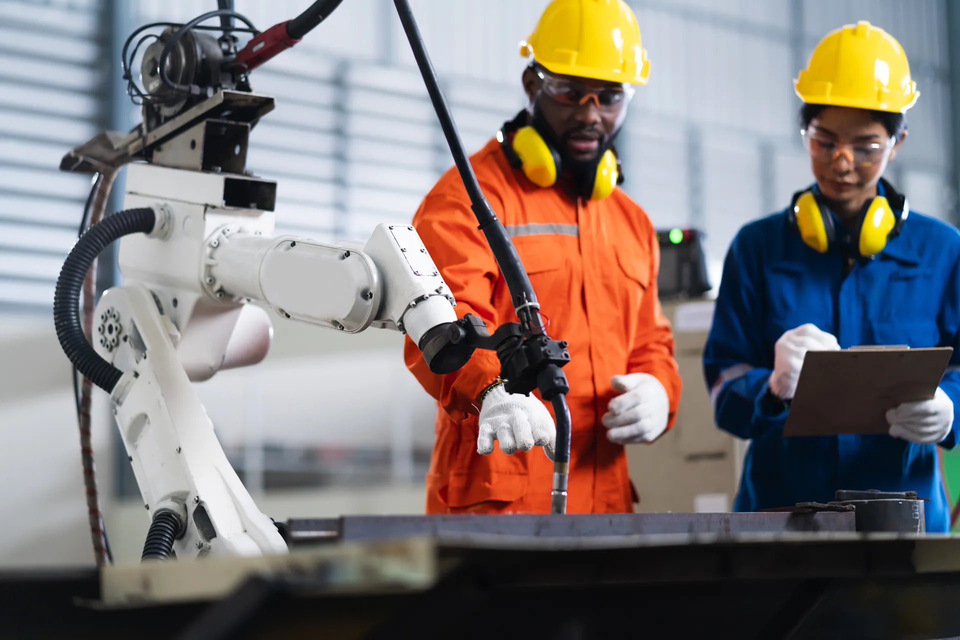 Engineers inspecting and commissioning a robotic welding arm